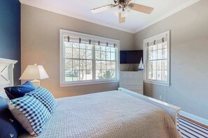 A bedroom with a bed, two windows, a ceiling fan, and a dresser. - Bayside Resort house w/ tennis/basketball court, shared sauna, & board games (Selbyville)