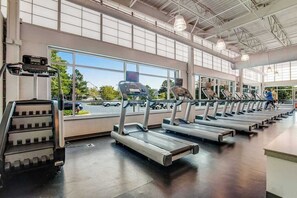 Een sportschool met loopbanden, een stair climber en grote ramen.