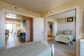 Ein Schlafzimmer mit Bett, Spiegel, Kleiderschrank und einer Tür zum Badezimmer.