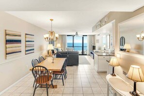 A modern interior with a dining area, kitchen, and living space. - Sea Colony Ocean 6th-floor condo with balcony, pool, hot tub, & ocean view (Bethany Beach)