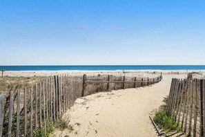 A sandy beach path with a wooden fence leading to the ocean. - Sea Colony Ocean 6th-floor condo with balcony, pool, hot tub, & ocean view (Bethany Beach)