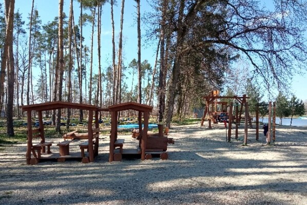 A playground with wooden structures and benches in a forested area. - Beautiful apartment in villa for 6 guests with WIFI, A/C, TV, patio and pets allowed (Dvůr Králové Nad Labem)