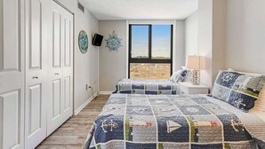 Een slaapkamer met een groot bed, twee nachtkastjes, een raam met uitzicht en een kledingkast.