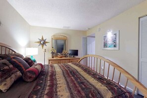 A bedroom with a bed, a dresser, a television, a mirror, and a star-shaped wall decoration. - Sea Colony 9th floor condo with tennis court, elevator, gym & ocean view (Bethany Beach)