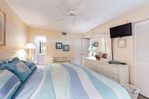 A bedroom with a bed, a dresser, a ceiling fan, a television, and a door. - Sea Colony Ocean 1st-floor condo with pool & basketball court (Bethany Beach)