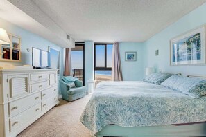 A bedroom with a bed, dresser, and a view of the beach. - Sea Colony Ocean 5th-floor condo with tennis court, basketball court, & pool (Bethany Beach)