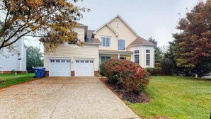 A two-story house with a front garage, a covered porch, and a well-maintained lawn. - Bethany Lakes house with a community pool, gym, tennis & free WiFi (Bethany Beach)