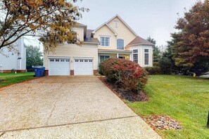 A two-story house with a front garage, a covered porch, and a well-maintained lawn. - Bethany Lakes house with a community pool, gym, tennis & free WiFi (Bethany Beach)