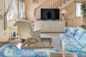A living room with a television, a sofa, a chair, and a coffee table. - South Bethany canal-front house w/ grill, boat dock, and outdoor shower (Bethany Beach)