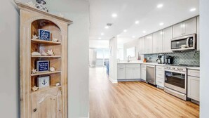 A modern kitchen with white cabinets, stainless steel appliances, and a wooden floor. - Sea Colony Ocean 14th floor condo with WiFi, basketball court, and tennis court (Bethany Beach)