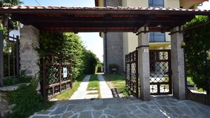 Um caminho de pedra leva a um portão com uma pérgola.