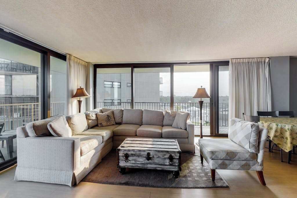 Een moderne woonkamer met een hoekbank, een klein bijzettafeltje en een vintage koffer.