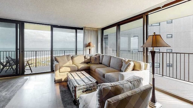 Uma sala de estar moderna com um sofá modular, um baú antigo e um abajur de chão.