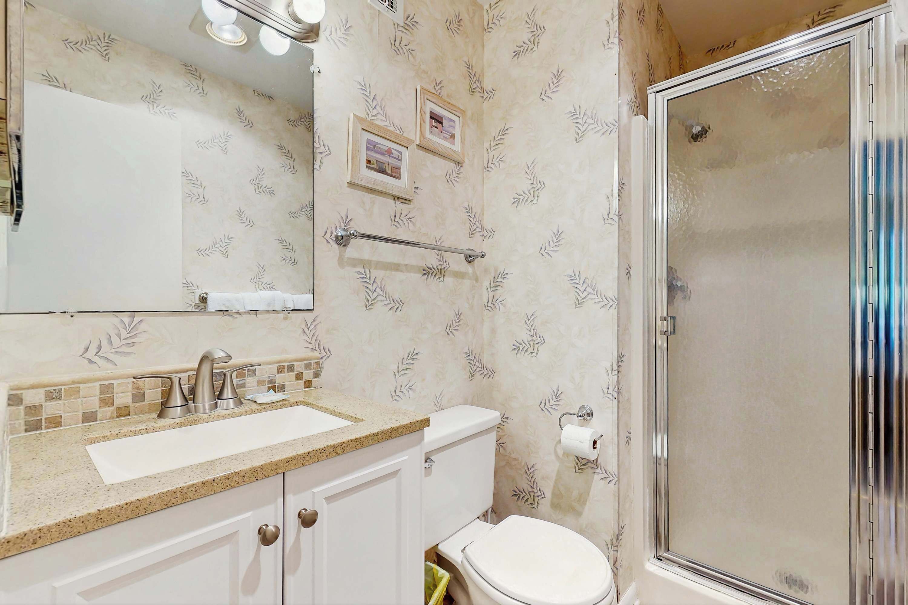 A bathroom with a sink, toilet, and shower.