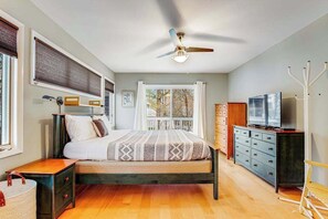 A bedroom with a bed, bedside tables, a dresser, a television, and a ceiling fan. - Sea Colony Tennis townhouse with gym, pool, tennis court, & basketball court (Bethany Beach)