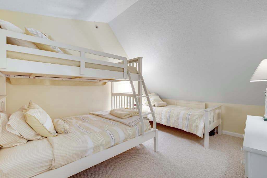 Ein Zimmer mit Etagenbetten, einem Schreibtisch und einer Lampe.