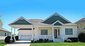 A two-story house with a garage, a covered porch, and a well-maintained lawn. - Bayside Resort house w/ basketball court, fireplace, gym, and golf on-site (Selbyville)