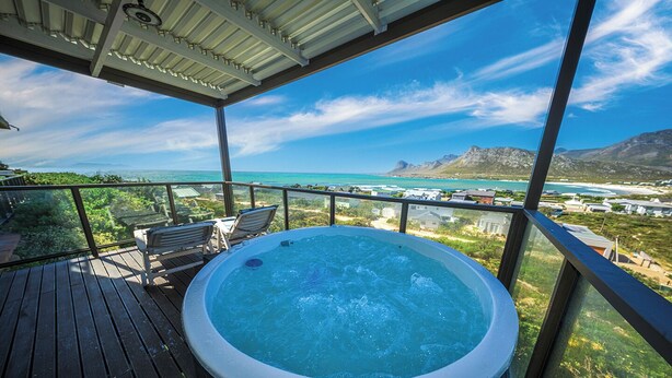 A hot tub on a wooden deck with a view of the ocean and mountains. - The Butterfly Villa (Pringle Bay)