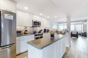 A modern kitchen with white cabinets, stainless steel appliances, and a central island. - Sea Colony Ocean 7th floor condo w/free WiFi, tennis court, and elevator (Bethany Beach)
