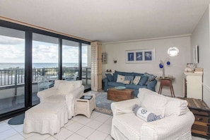 A balcony with a view of the sea, a white sofa set, and a blue sofa set. - Sea Colony Ocean 2nd floor condo w/ basketball court, pool, and balcony (Bethany Beach)