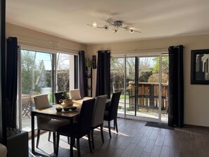 Ein Essbereich mit Tisch, Stühlen und Deckenventilator.