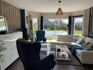 Ein modernes Wohnzimmer mit einer Couch, einem Sessel und einem Couchtisch.