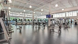 A spacious gym with various exercise machines, large windows, and a high ceiling. - Sea Colony Ocean 3rd floor condo w/ pool, tennis court, and elevator (Bethany Beach)