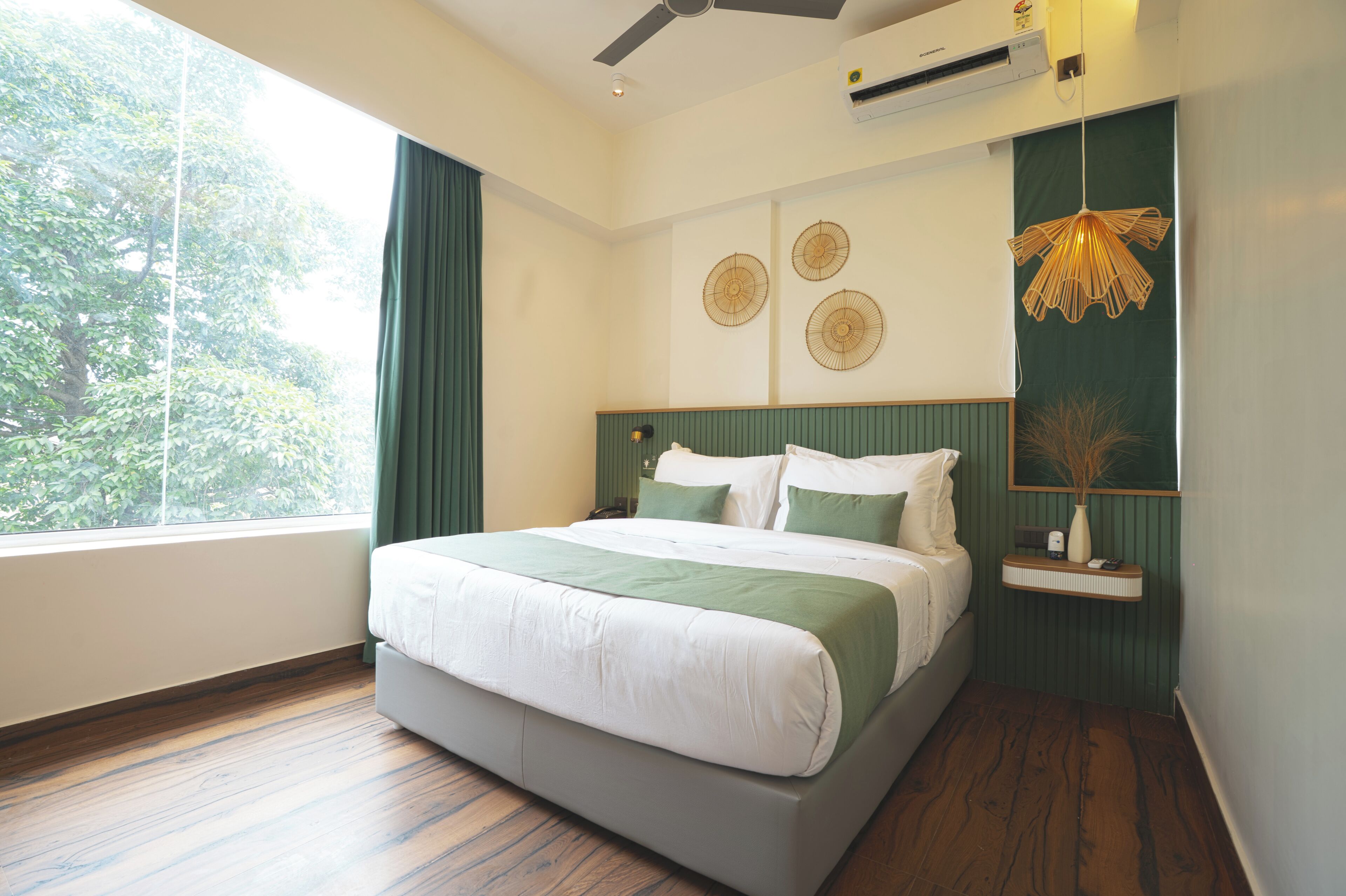 A bedroom with a bed, a window, a ceiling fan, and a wall-mounted air conditioner.