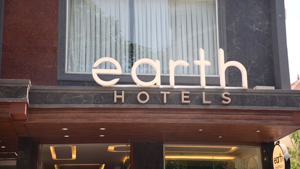 The exterior of Earth Hotels with a large sign above the entrance. - Earth Hotels Hebbal (Bengaluru)