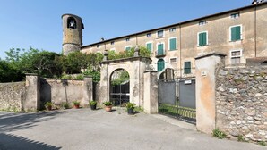 A historic building with a bell tower, stone walls, and potted plants.