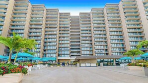 A high-rise hotel with multiple balconies, outdoor seating, and a central courtyard. - Sea Colony Ocean 6th-floor condo wit balcony, tennis court, & basketball court (Bethany Beach)