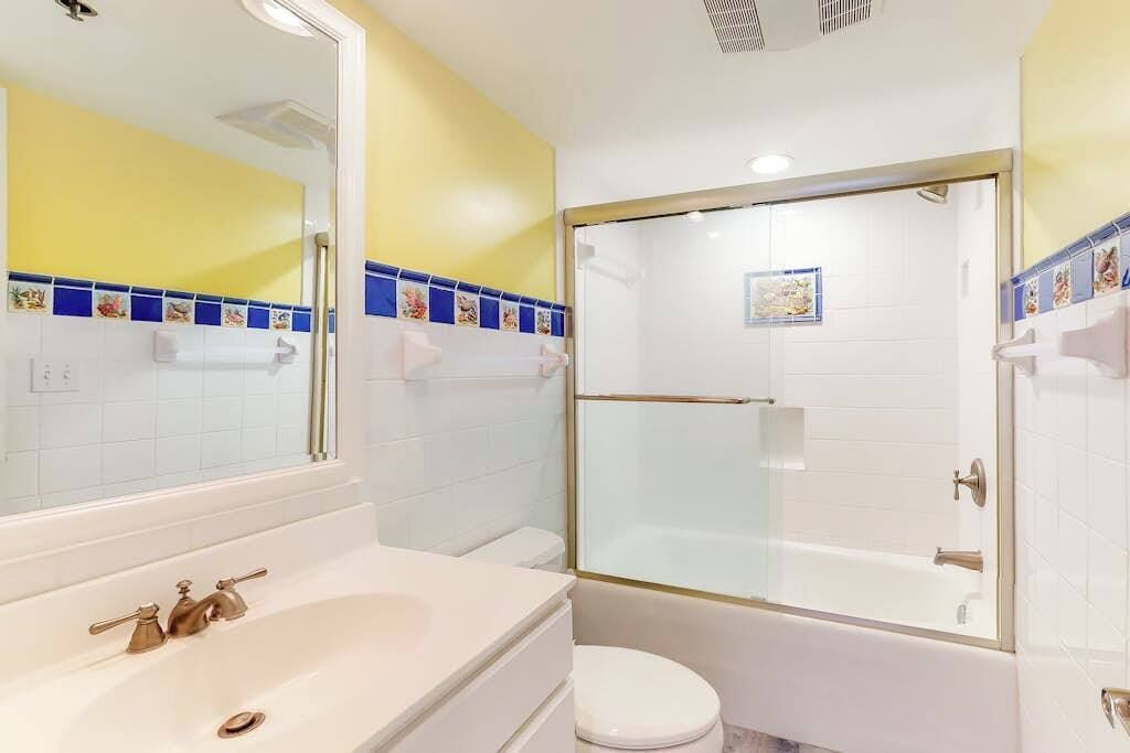 A bathroom with a bathtub, toilet, and sink.