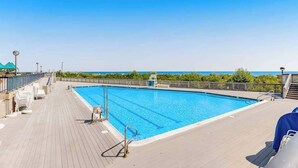 Una piscina en una terraza con vista al océano.