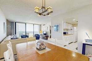 Ein modernes Wohnzimmer mit Esstisch, Sofa und Küchenbereich.