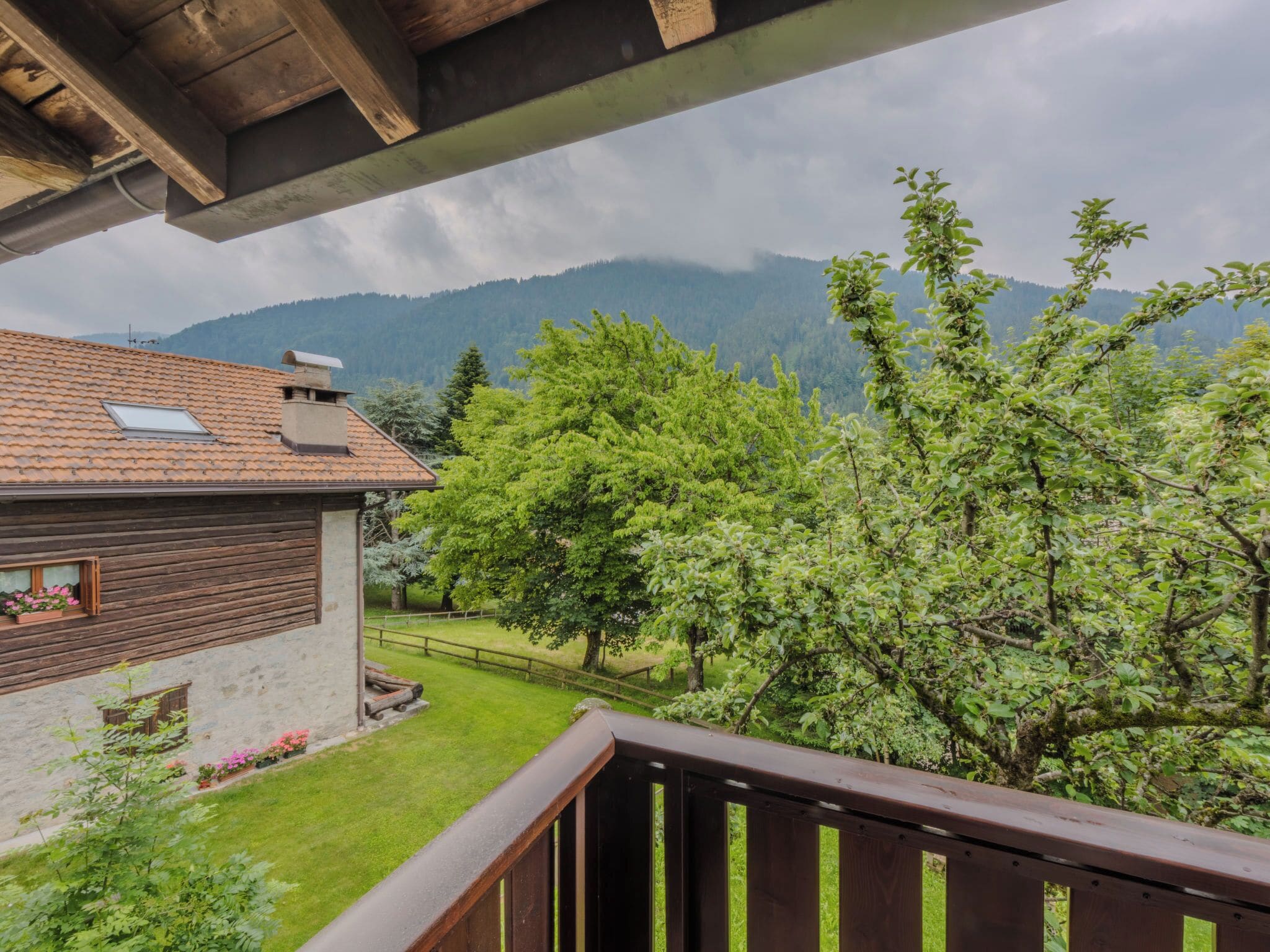 Een houten balkon met uitzicht op een berglandschap.