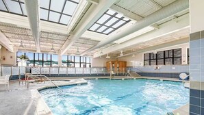 An indoor swimming pool with clear skylights, a changing room, and a view of the outdoors. - Sea Colony Ocean 8th floor condo w/ pool, free WiFi, & basketball court (Bethany Beach)