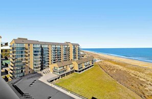Ein mehrstöckiges Hotel mit Balkonen mit Blick auf einen Strand.