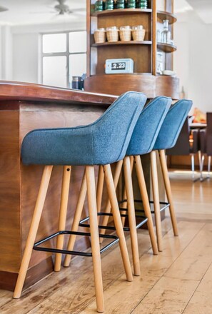 A bar area with wooden stools and a metal bar counter. - Kensington 6-bed 4000 Sqft AC Parking (London)