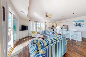 Ein modernes Wohnzimmer mit Sofa, Fernseher und Essbereich.