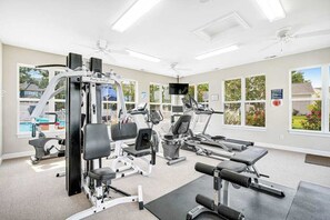 A gym with various exercise equipment, large windows, and a ceiling fan. - Swann Cove dog-friendly house w/ balcony, gas fireplace, and shared pool (Selbyville)