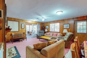 A cozy room with wooden walls, a sofa, a chair, a small table, and a bench. - Sea Del Estates Home with Outdoor Shower, Grill, & Community Beach & Tennis (Bethany Beach)