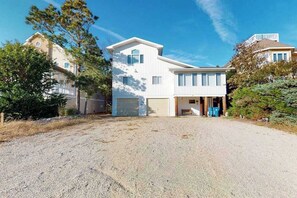 A two-story house with a garage, a driveway, and surrounding trees. - Sea Del Estates Home with Outdoor Shower, Grill, & Community Beach & Tennis (Bethany Beach)