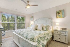 A bedroom with a bed, nightstands, a ceiling fan, and a window with blinds. - Sea Colony Tennis 2nd floor condo w/ gym, basketball court, and lake view (Bethany Beach)