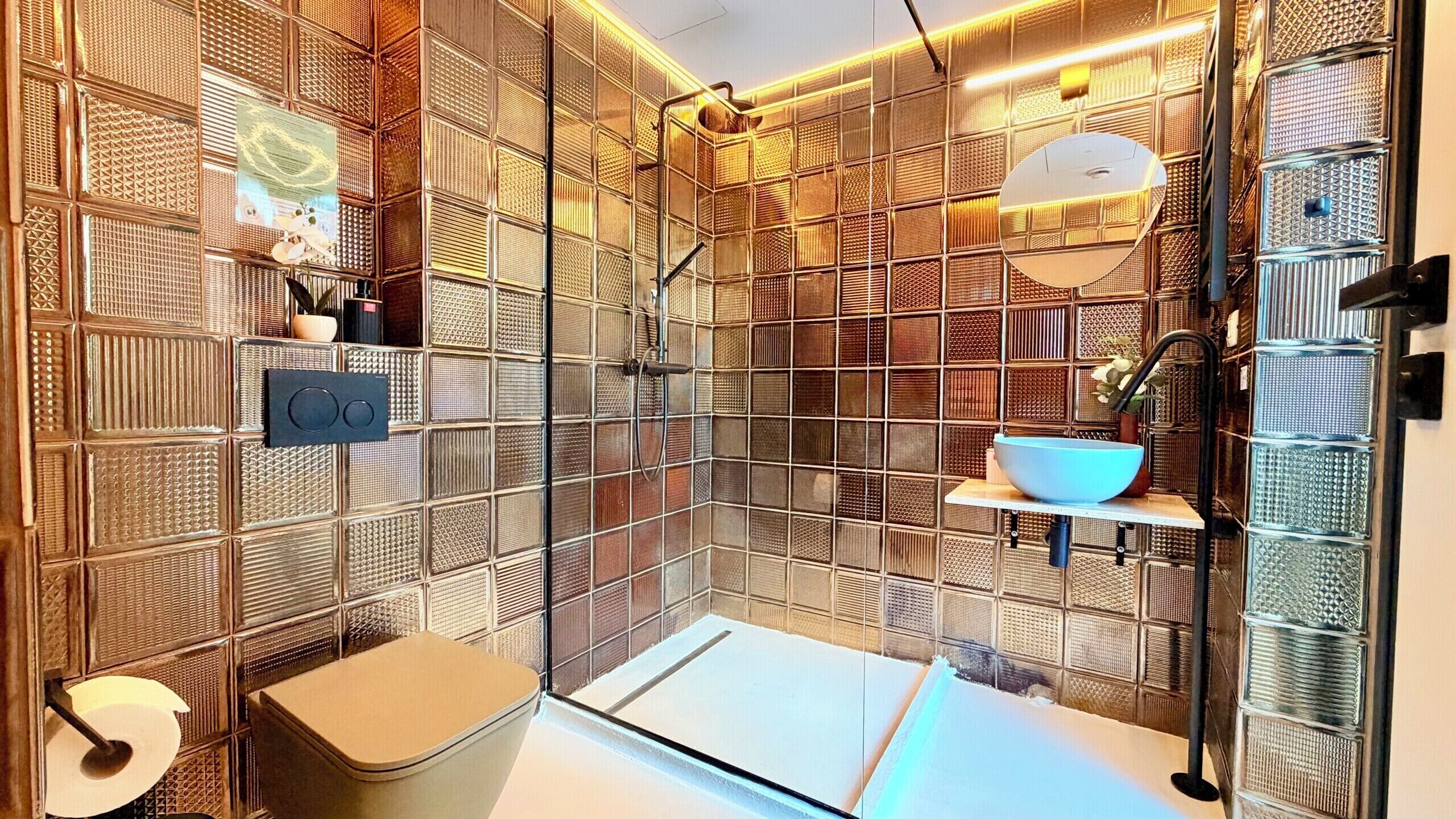 Un baño moderno con cabina de ducha de vidrio, inodoro y lavamanos.