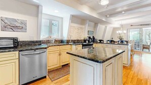 Una cocina moderna con encimeras de granito, electrodomésticos de acero inoxidable y una isla grande.