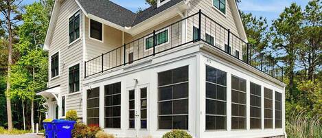 A two-story house with a large bay window, a stone foundation, and a garage.