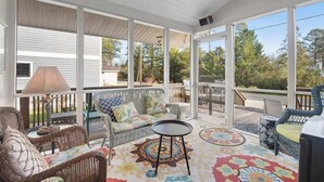 A covered porch with wicker furniture, a table, and a patterned rug. - Town of Bethany Beach Home Near Fun Activities & Adventures w/Free WiFi & WD (Bethany Beach)