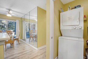 A room with a dining area, a white refrigerator, and a sliding glass door leading to an outdoor space. - Sea Colony Escape with Shared Pool, Tennis Courts, & Free Shuttle to Beach (Bethany Beach)