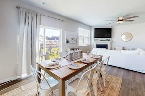 Une chambre d’hôtel moderne dotée d’un coin repas, d’un canapé, d’une télévision et d’une cheminée.