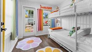 A room with a bunk bed, a door with curtains, and a window with a view. - Hippie House-5 bedroom, Sleeps 12! Pool, Basketball, Mini golf, Pickleball Ct! (Bradenton)